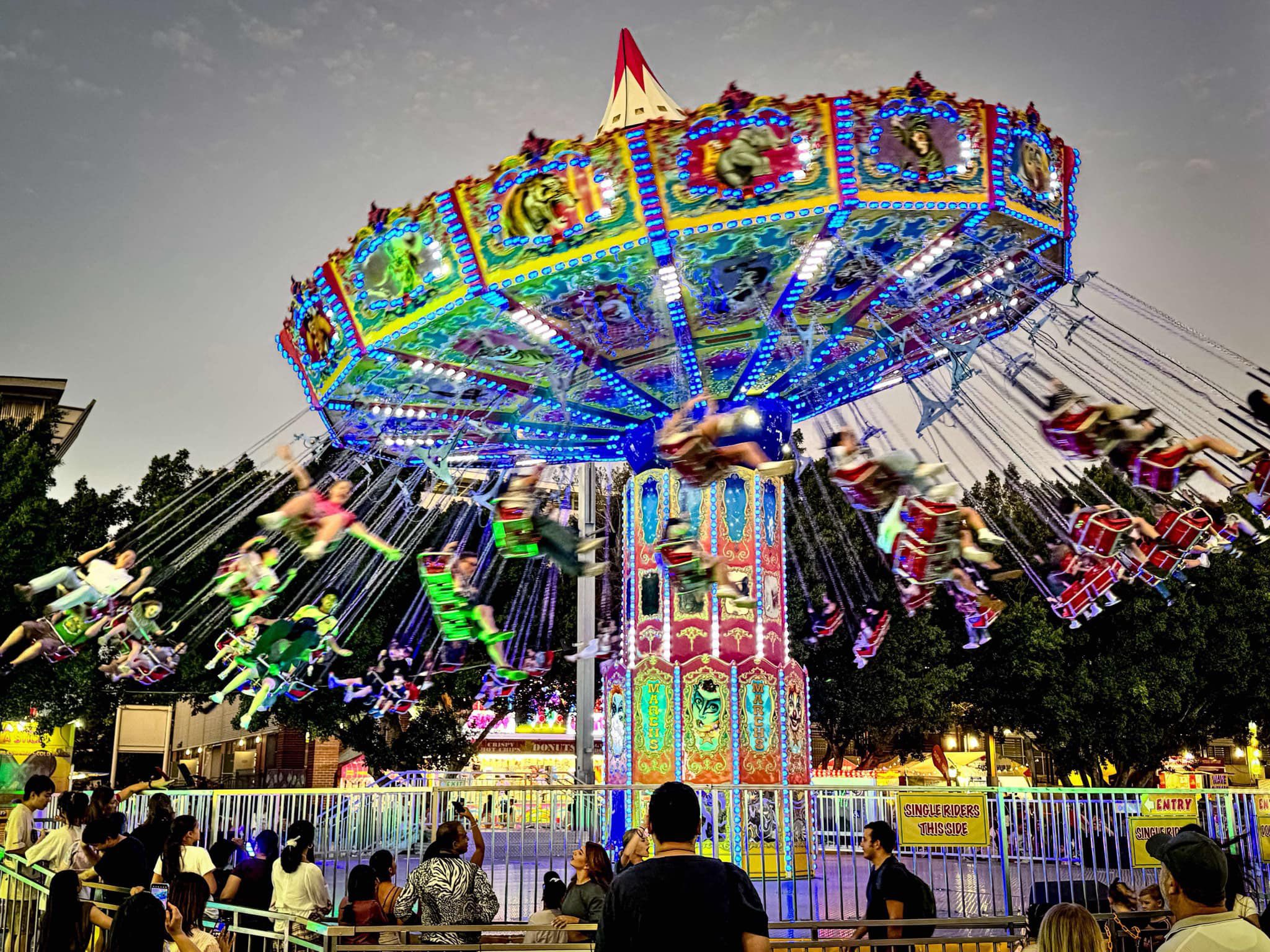 Wave Swinger ride lit up at sunset